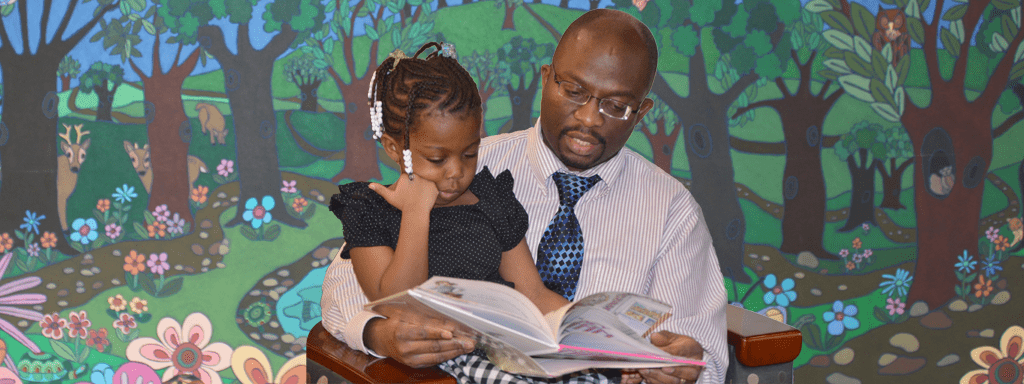 Father reading to daughter