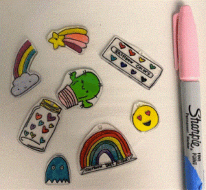 examples of shrink art (rainbow, kawai cactus, hearts in a jar, smiley face, water color pallet) and a pink sharpie marker.