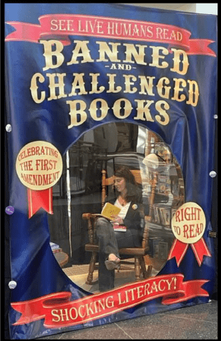 Mayor Megan Foster Reading in the Library's live banned books display during banned books week 2023