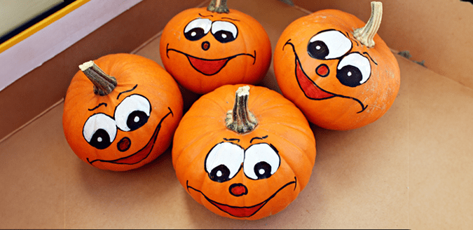 Mini pumpkins with painted faces on them.