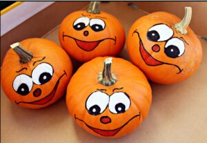 Mini pumpkins with painted faces on them.