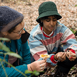 Two women showing each other the mushrooms they found on a foray