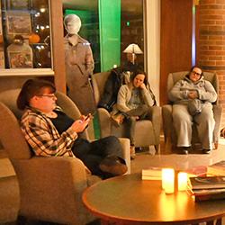 Community members telling spooky stories in front of the Library Hearth