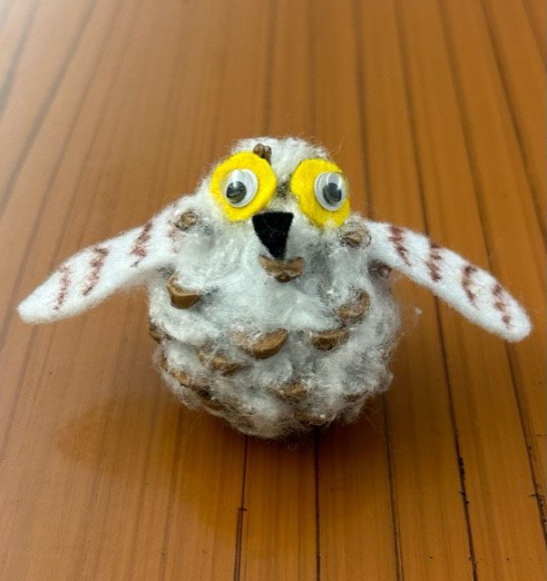 An owl make out of a pinecone and felt.