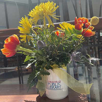 A bouquet of flowers in a Coralville Public Library mug.