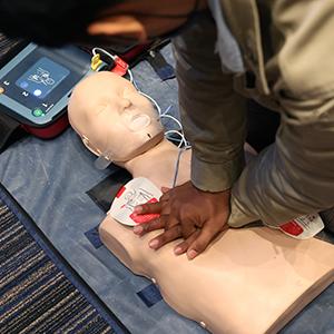 A man practicing CPR on a dummy