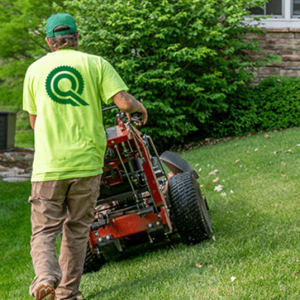 Quality Care employee mowing a lawn